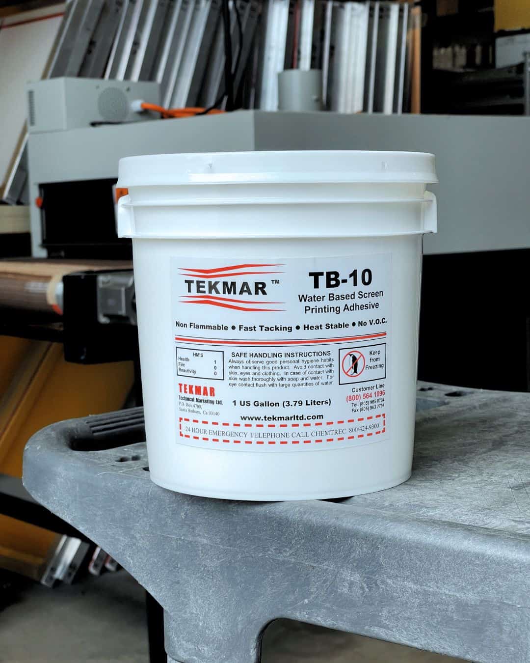 Tekmar TB-10 high-solids acrylic pallet adhesive bottle on a screenprinting table, showing its opaque white appearance. Industrial pallet adhesive exclusively stocked at Jones Brothers in Melbourne for professional screenprinters across Australia.