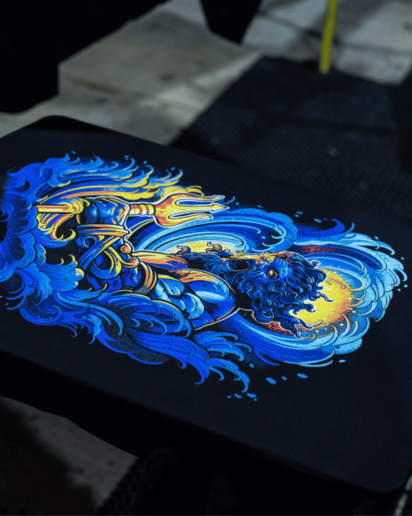 Hand-printed Project Poseidon artwork by Minnie Longstaff, screenprinted using Union Ink’s UPLC UNI MIX range supplied by Avient. Printed by BlackDog Ink on an M&R press, with garments supported by AS Colour. Materials supplied by Jones Brothers in Melbourne, Australia. Professional screenprinting process photo.