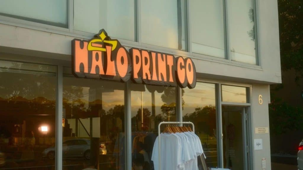 Behind-the-scenes view of garment printing process at Halo Print Co, showing workflow and shop environment