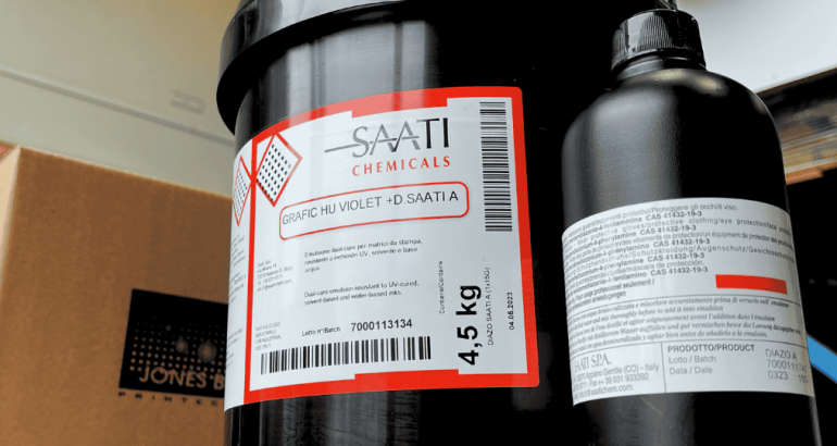 SAATI Chemicals container used in screen printing processes in a workshop setting.